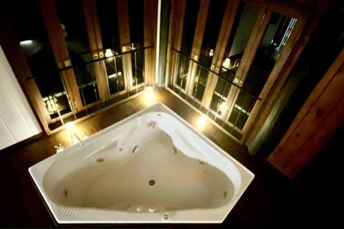 a large bath tub in a bathroom with lights at BUTTERFLY BEND - 3 Bedroom Daintree Beach House in Cow Bay