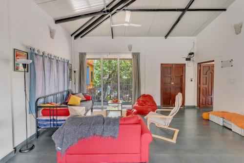 uma sala de estar com um sofá vermelho e cadeiras em Kiki Villa em Arambol