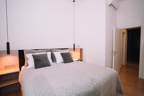 a bedroom with a large white bed with two pillows at Luxury wellness apartment SHA in Osijek