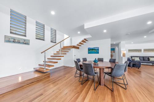 a dining room and living room with a table and chairs at Whitsunday living on Hillcrest in Airlie Beach