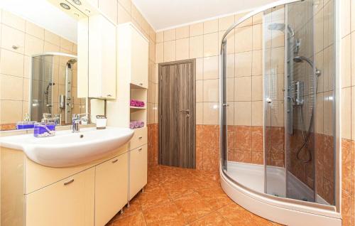 a bathroom with a sink and a shower at Amazing Apartment In Okrug Gornji With House Sea View in Trogir