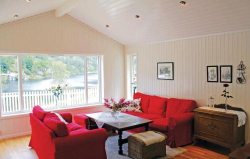 a living room with red furniture and a large window at 3 Bedroom Gorgeous Home In Lyngdal in Lyngdal