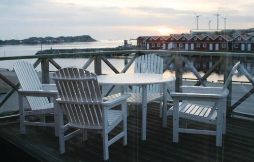a white table and chairs on a dock with the water at 2 Bedroom Stunning Home In Rönnäng in Rönnäng