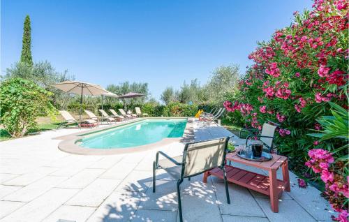 einen Pool mit Stühlen, einem Tisch und Blumen in der Unterkunft Villa Luca in Vitorchiano