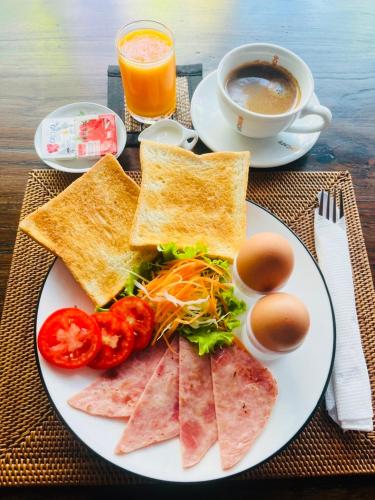 a plate of food with toast and eggs and a cup of coffee at Baipho Lifestyle in Patong Beach