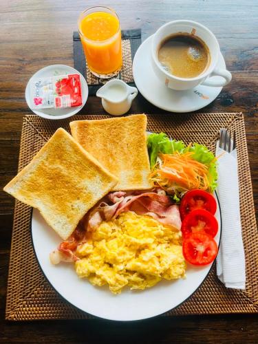 a plate of food with eggs and toast and a cup of coffee at Baipho Lifestyle in Patong Beach