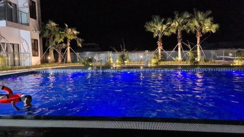 een persoon die 's nachts in een groot zwembad zwemt bij Tim Homestay Nera Garden in Hue