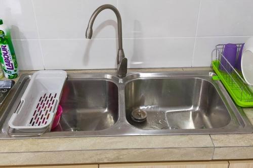 a kitchen sink with a dish drying rack next to it at Sunsky Condominium Homestay in Miri