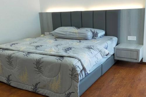 a bedroom with a bed with a wooden floor at Sunsky Condominium Homestay in Miri