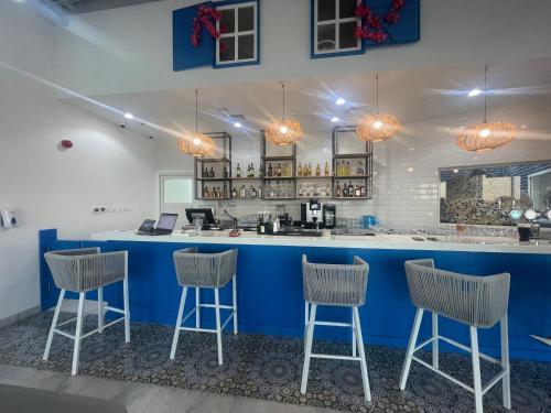 a blue bar with three stools in a room at Yas Island - 2 Bedrooms, 2 toilet with shared Pool & Parking in Abu Dhabi