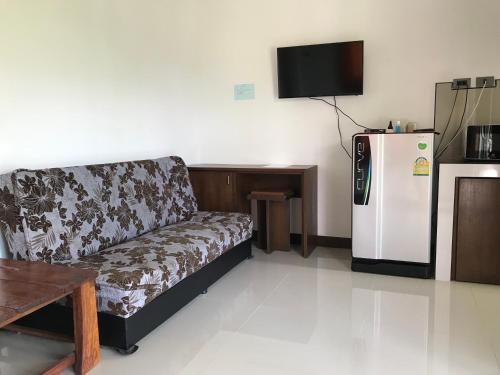 a living room with a couch and a refrigerator at Tara House in Ko Lanta