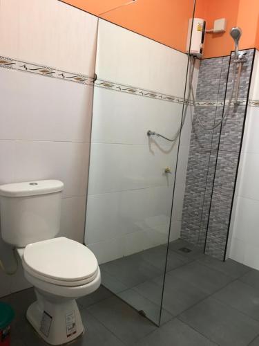 a bathroom with a toilet and a shower at Tara House in Ko Lanta
