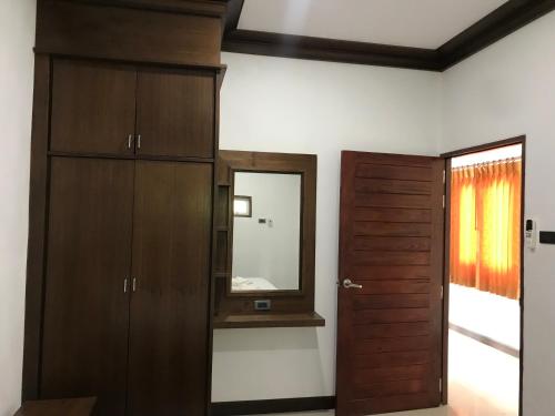 a room with a mirror and a wooden door at Tara House in Ko Lanta