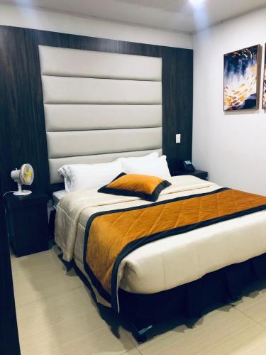 a bedroom with a large bed with a large headboard at Hotel San Antonio Guarne in Guarne