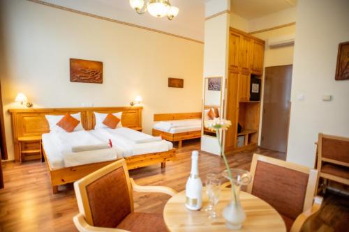 a hotel room with a bed and a table and chairs at Hotel Manzard Panzio in Budapest
