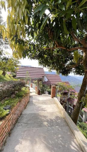 a walkway leading to a house with a brick wall at SANKARA GARDEN in Pantai