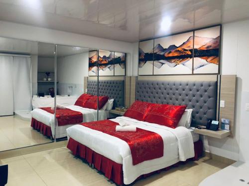 a bedroom with two beds with red pillows at Hotel San Antonio Guarne in Guarne