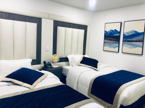 a bedroom with two beds with blue and white at Hotel San Antonio Guarne in Guarne