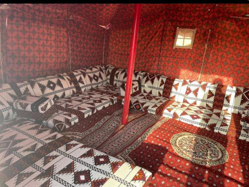 a room with four beds in a room with red walls at استراحة لبنان ا في بنبان Istraha in Riyadh
