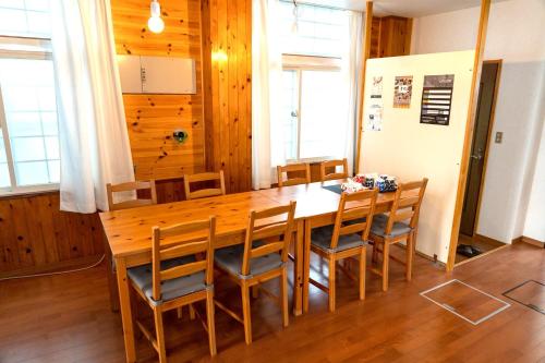 una sala da pranzo con un grande tavolo in legno e sedie di Asagama House a Nozawa Onsen