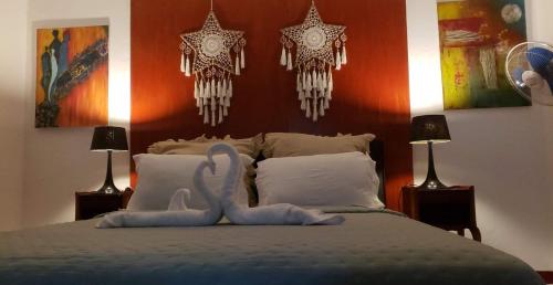 a bedroom with a bed with two swans on it at Le Dhow in Moroni