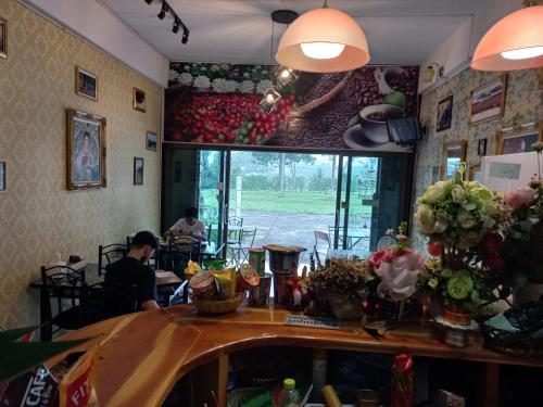 a bar in a restaurant with people sitting at tables at Amaretto Hostel in Surat Thani