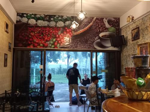 a restaurant with a painting of tomatoes on the wall at Amaretto Hostel in Surat Thani