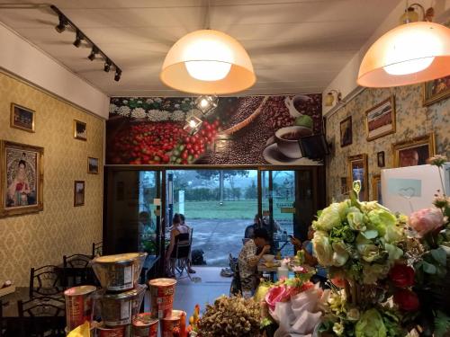 a room with a table with a bunch of flowers at Amaretto Hostel in Surat Thani