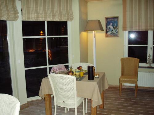a dining room with a table and chairs and windows at B&B Vallis Dyliae in Korbeek-Dijle