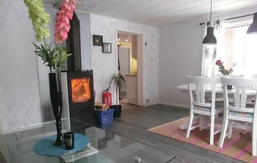 a living room with a fireplace and a table and chairs at 3 Bedroom Stunning Home In Annerstad in Annerstad