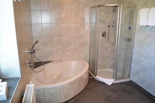 e bagno con vasca e doccia. di Hotel Rietzerhof a Rietz