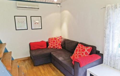 a living room with a brown couch with red pillows at Beautiful Home In Färjestaden With Wifi in Färjestaden