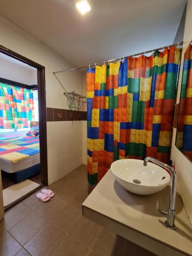 La salle de bains est pourvue d'un rideau de douche coloré et d'un lavabo. dans l'établissement IPSA Lego Amari Water Park Lagoon Resort Bukit Katil Melaka, à Malacca