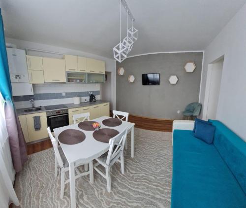 a kitchen and dining room with a white table and chairs at DDDD Apartament in Cavnic