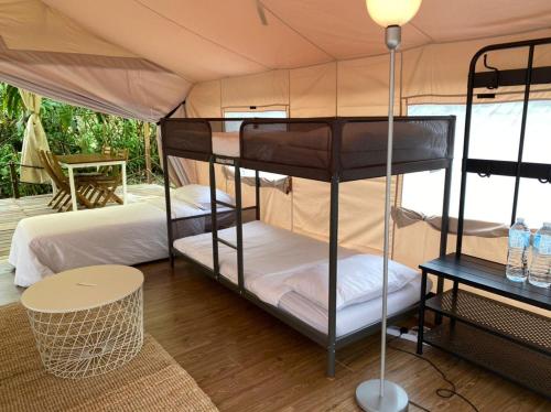 Canopy Villa Nuang Hill في بينتونغ: غرفة نوم بسريرين في خيمة