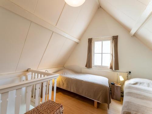 een slaapkamer op zolder met 2 bedden en een raam bij Cosy holiday home in Veere near lake in Veere