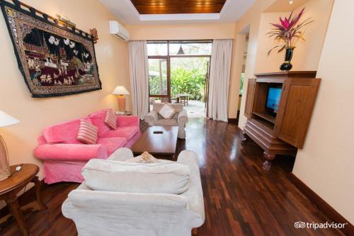 a living room with a pink couch and a tv at The Hotel @ Tharabar Gate in Bagan
