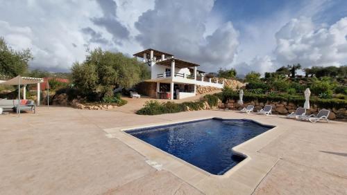 een villa met een zwembad en een huis bij Finca Zayas Casa Rural & Guest Suites in Periana