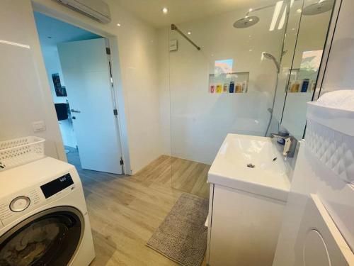 La salle de bains est pourvue d'un lave-linge et d'un lavabo. dans l'établissement Prachtig guesthouse met gratis parkeren, à Maasmechelen