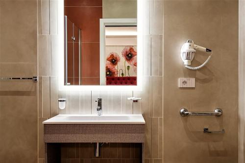 y baño con lavabo y espejo. en Petit Hotel, en Prato