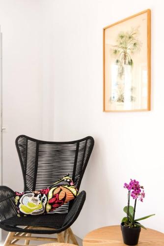 a black chair with a pillow on it next to a table at Koumi Homes Mykonos in Elia