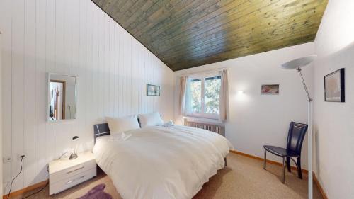 a bedroom with a large bed with a wooden ceiling at Palois Family Apartment Centre Lenzerheide in Lenzerheide