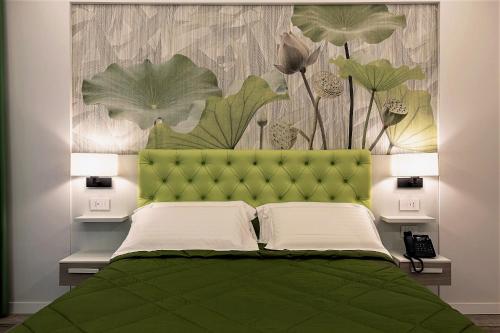 1 dormitorio con cama verde y cabecero verde en Petit Hotel, en Prato