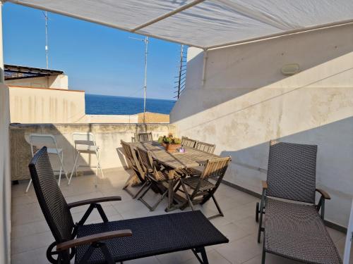 敘拉古的住宿－SEA-VIEW TERRACE & BIKES Moon Ortigia Holiday Home，一个带桌椅的海景阳台