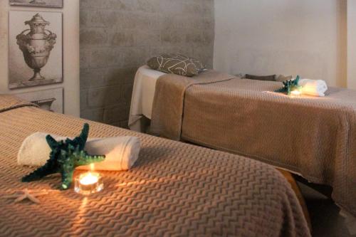 a room with two beds with candles on them at Hotel Tonnara Trabia in Trabia