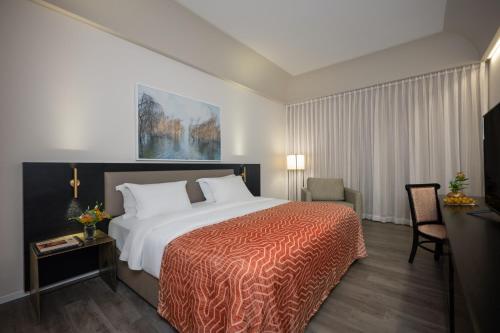 a hotel room with a large bed and a chair at Dan Jerusalem Hotel in Jerusalem