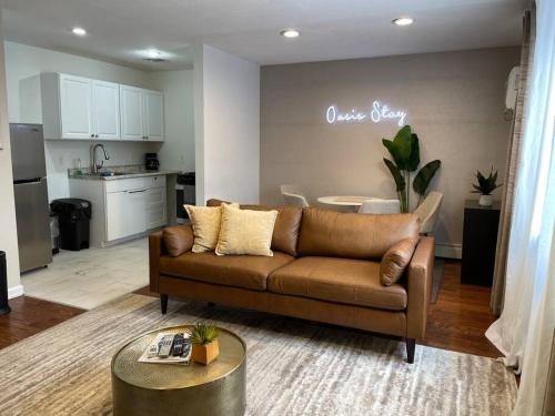a living room with a brown couch and a kitchen at Oasis Stay NY, 2BR Cozy Home in a 2Family House, 18min from the City in Unionport