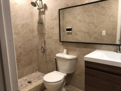 a bathroom with a toilet and a sink and a shower at Oasis Stay NY, 2BR Cozy Home in a 2Family House, 18min from the City in Unionport