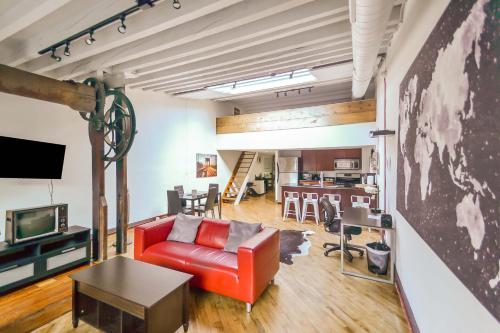 a living room with a red couch and a tv at The Havana Lofts in Philadelphia