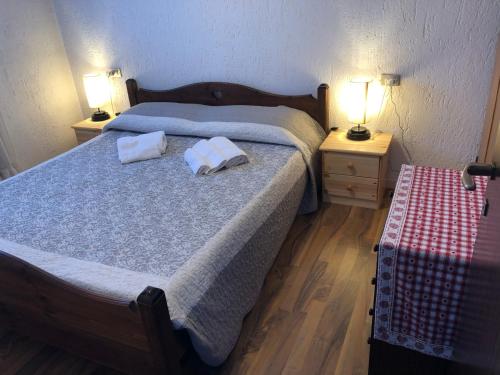 um quarto com 2 camas e 2 candeeiros nas mesas em M&M Maison Marilena lake Iseo (Montecampione) em Artogne